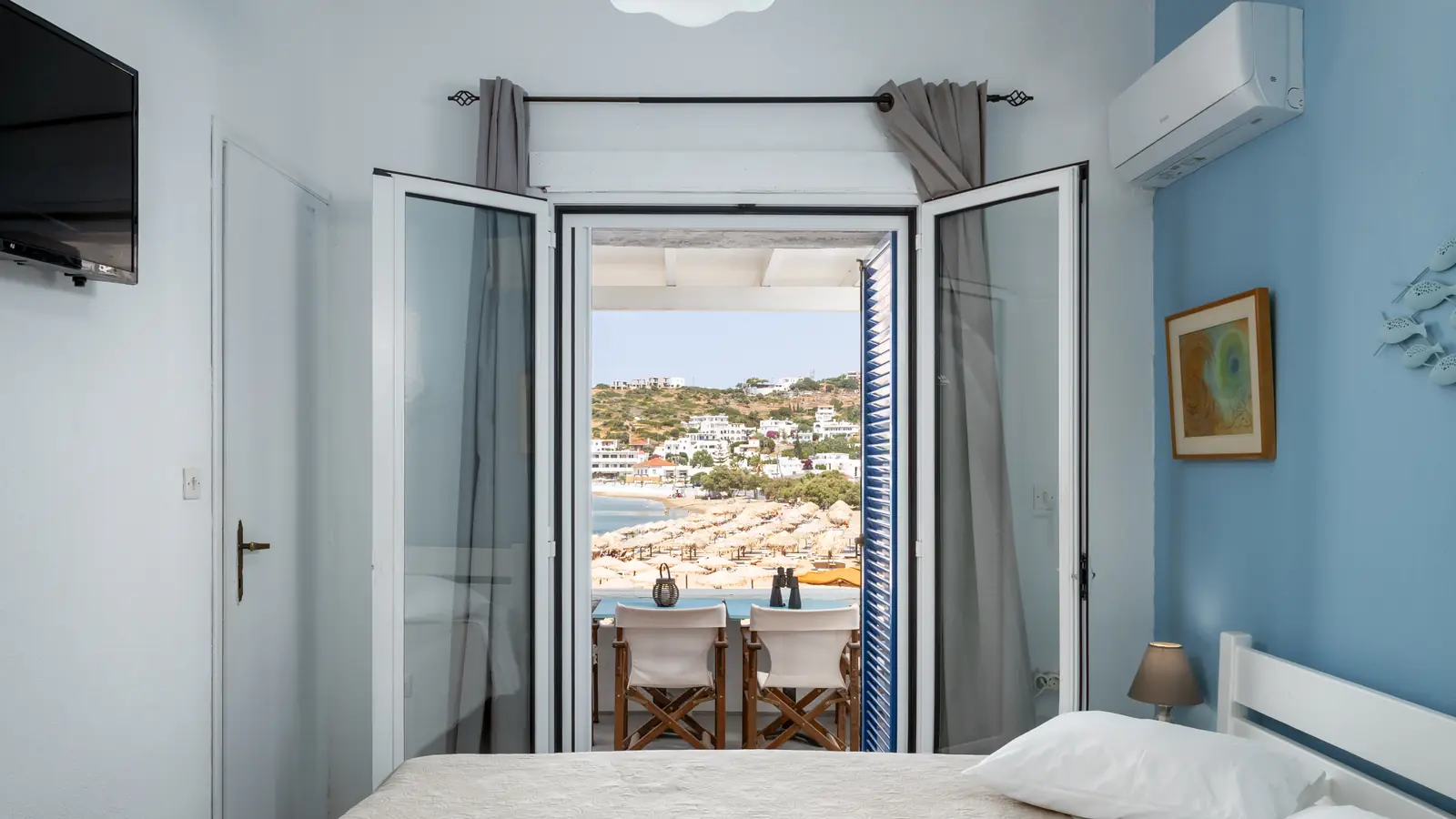 Schlafzimmer der Ferienwohnung mit offener Balkontür zur Bucht von Batsi, Andros