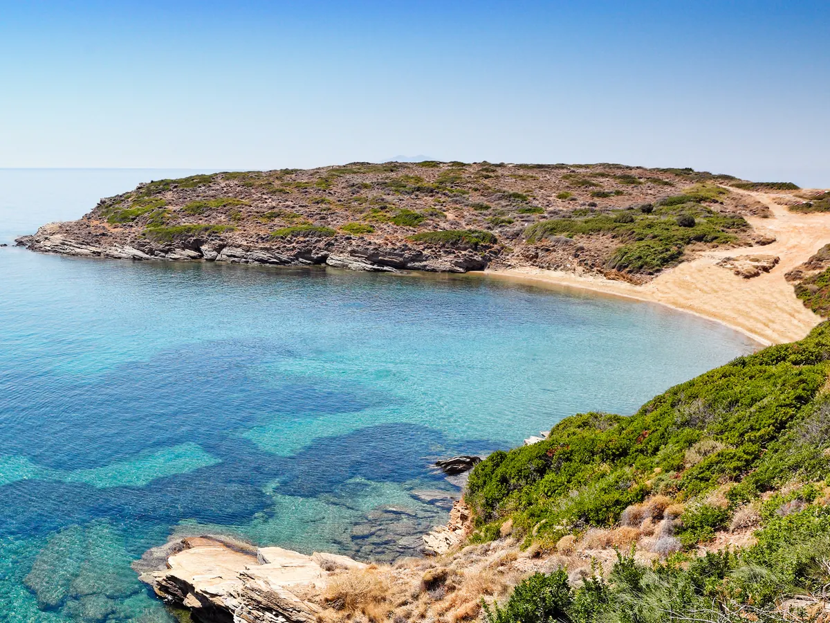 Αμμουδιά σε απάνεμο κόλπο με καταγάλανα νερά και χαμηλό ακρωτήρι, Άνδρος