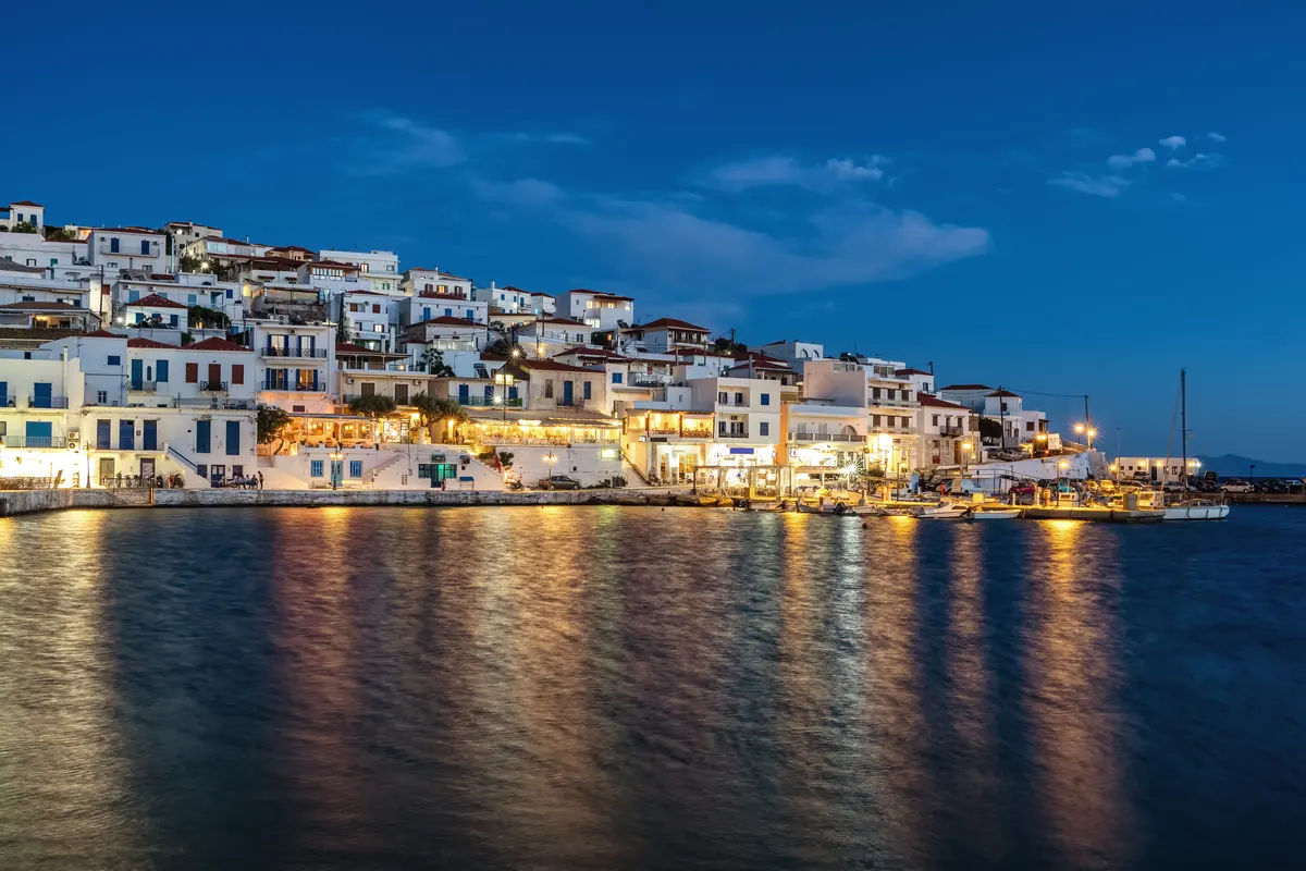 Το Μπατσί το βράδυ από τη θάλασσα, τα φώτα του χωριού να καθρεφτίζονται στο νερό, Άνδρος